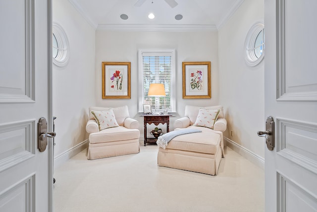 sitting room with light carpet, ornamental molding, and ceiling fan