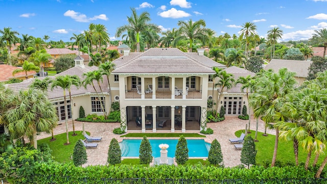 back of property with a balcony, a patio area, and french doors