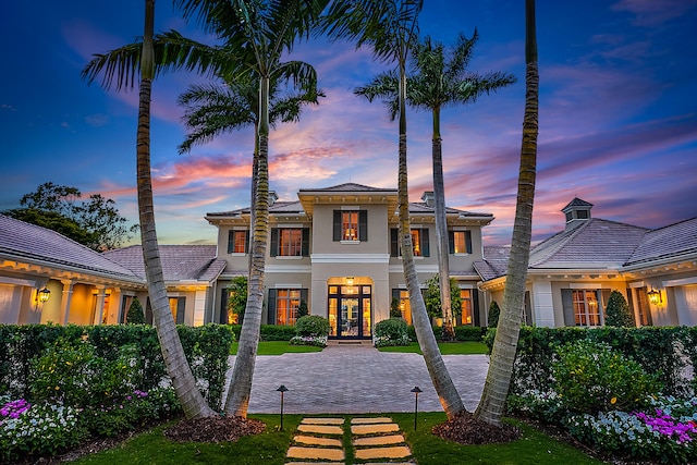 view of front of property featuring a lawn and french doors