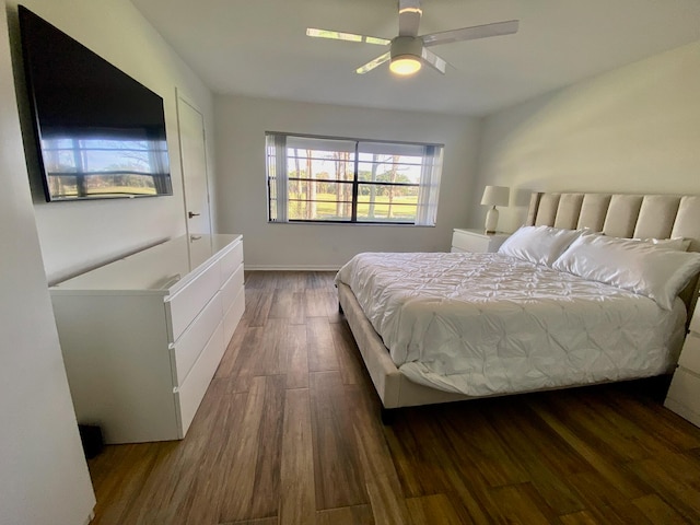 bedroom with dark hardwood / wood-style floors and ceiling fan