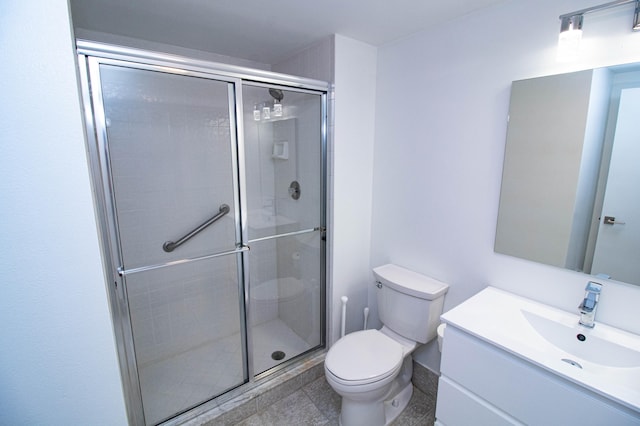 bathroom featuring walk in shower, toilet, vanity with extensive cabinet space, and tile flooring