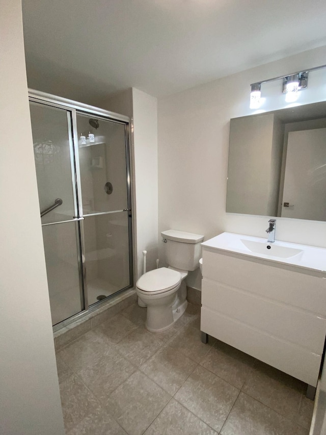 bathroom with toilet, vanity with extensive cabinet space, tile flooring, and walk in shower