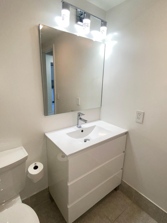 bathroom featuring toilet, tile flooring, and vanity