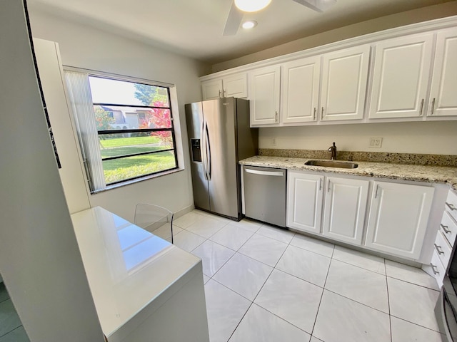 kitchen with light tile floors, ceiling fan, appliances with stainless steel finishes, white cabinetry, and sink