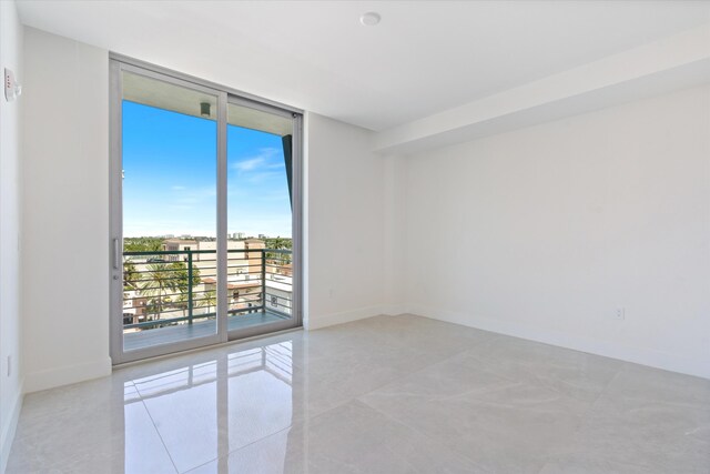 485 E Royal Palm Rd Unit 604, Boca Raton, FL 33432 - spare room with tile patterned flooring, floor to ceiling windows, and baseboards