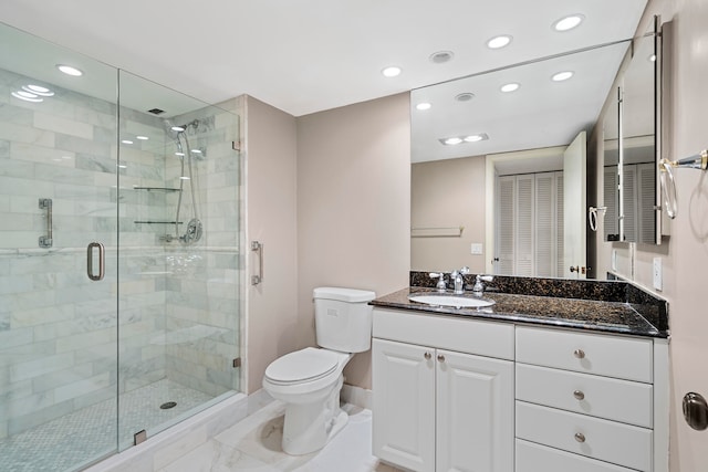 bathroom featuring toilet, a shower with shower door, large vanity, and tile flooring