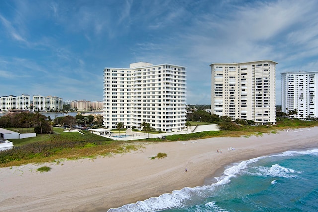 view of building exterior featuring a water view and a view of the beach