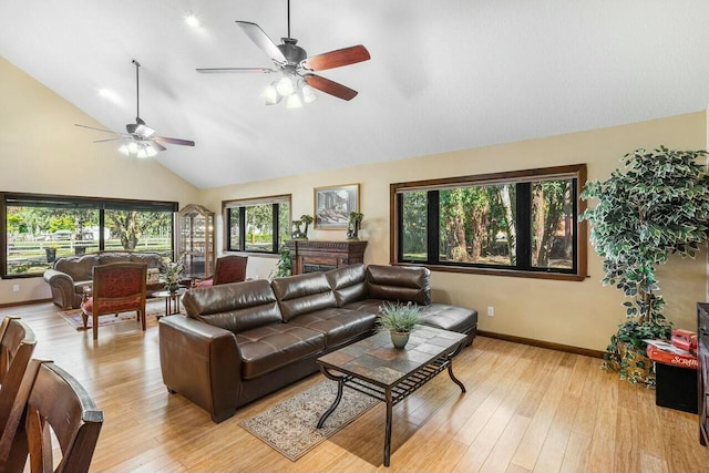 living room with plenty of natural light, ceiling fan, wood-type flooring, and lofted ceiling