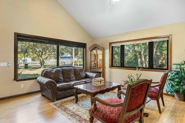 living room featuring a textured ceiling, ceiling fan, light hardwood / wood-style floors, and vaulted ceiling