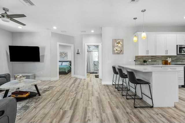 living room with light hardwood / wood-style floors and ceiling fan