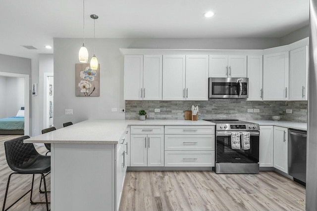 kitchen with stainless steel refrigerator, ceiling fan, pendant lighting, light hardwood / wood-style floors, and white cabinets