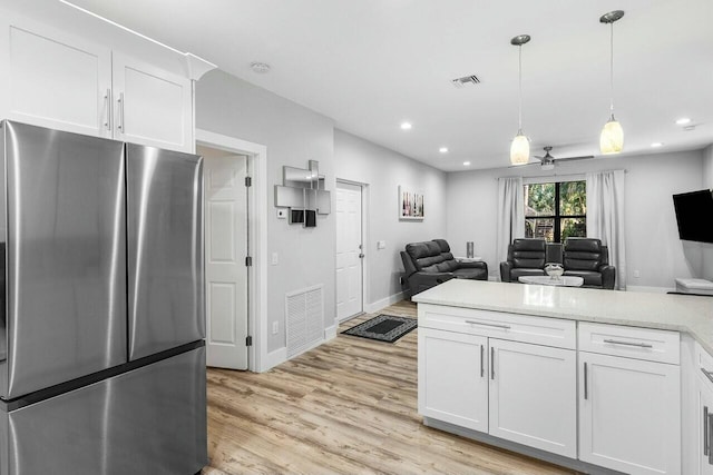 washroom with cabinets, light hardwood / wood-style flooring, and washer and clothes dryer