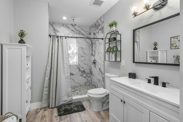 bathroom featuring toilet, wood-type flooring, vanity, and a shower with curtain