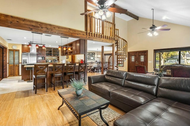 living room featuring ceiling fan, light hardwood / wood-style flooring, and vaulted ceiling