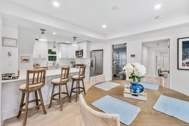 dining area with sink and light wood-type flooring