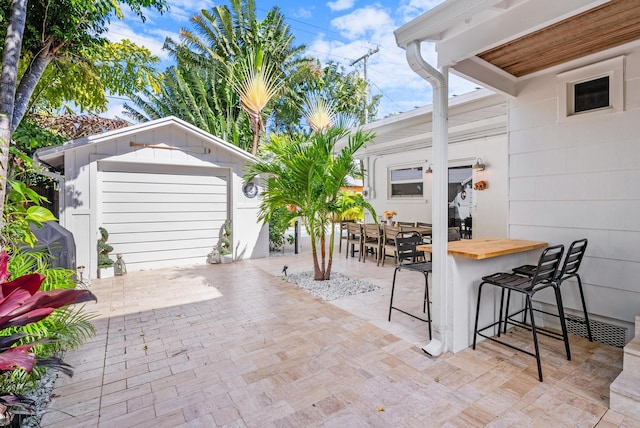 view of patio featuring exterior bar and an outbuilding