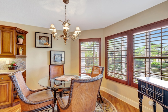 dining space featuring light hardwood / wood-style floors and a chandelier