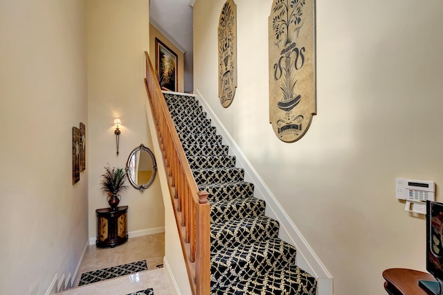 stairs with tile patterned floors and baseboards