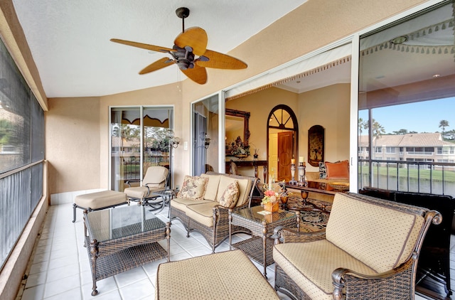 sunroom featuring lofted ceiling, ceiling fan, and a wealth of natural light