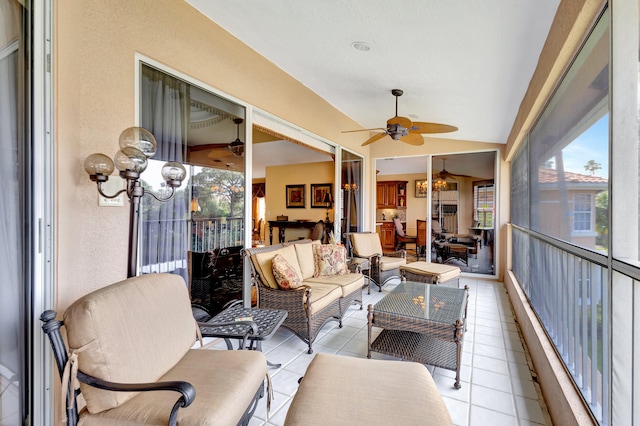 sunroom / solarium featuring ceiling fan with notable chandelier