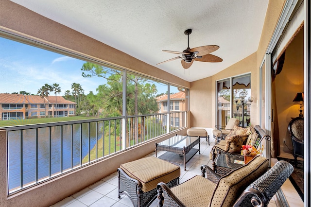 interior space featuring vaulted ceiling, ceiling fan, and a water view