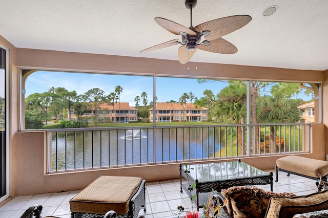 sunroom / solarium featuring plenty of natural light, a water view, and ceiling fan