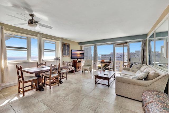 living room featuring ceiling fan, light tile patterned floors, and a healthy amount of sunlight