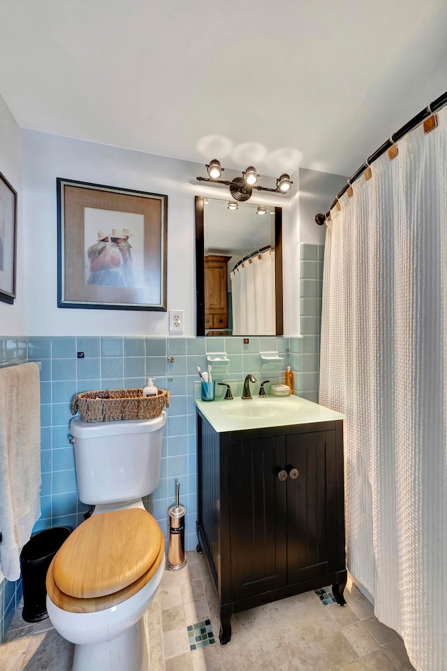 full bathroom featuring vanity, toilet, and tile walls