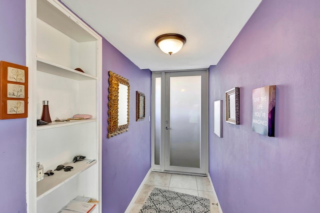 hall featuring baseboards and light tile patterned flooring