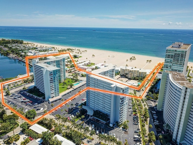 drone / aerial view featuring a beach view and a water view