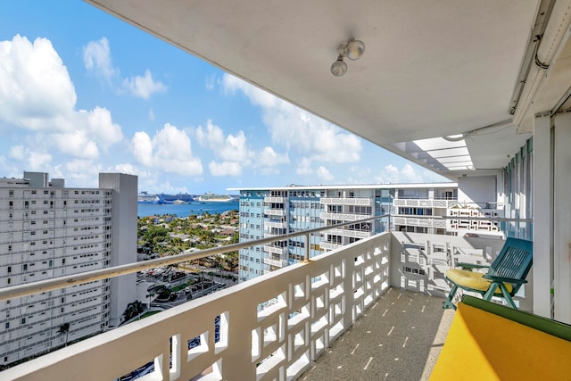 balcony featuring a water view and a city view