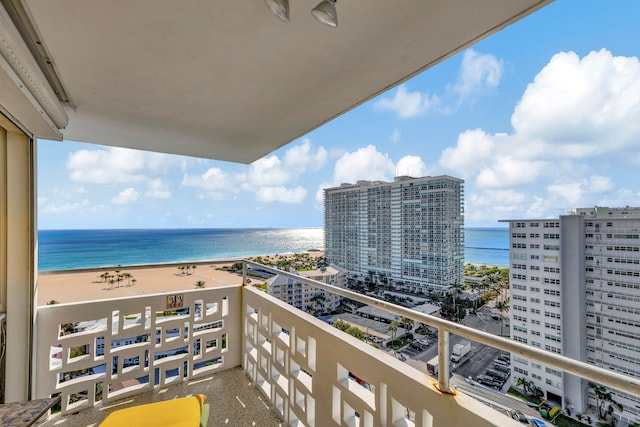 balcony with a water view and a view of the beach