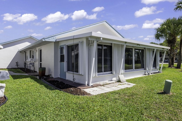 view of side of home featuring a lawn and stucco siding