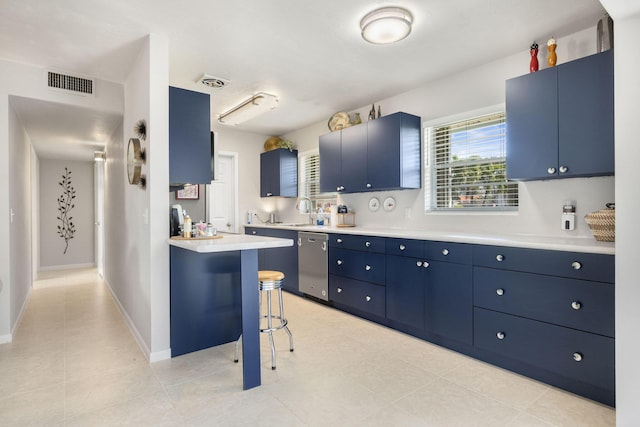 kitchen with a breakfast bar, blue cabinetry, light countertops, visible vents, and stainless steel dishwasher