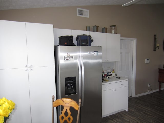 kitchen featuring white cabinets, stainless steel fridge with ice dispenser, dark wood-type flooring, and vaulted ceiling