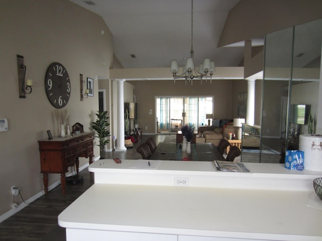 interior space with dark wood-type flooring, a notable chandelier, high vaulted ceiling, and ornate columns