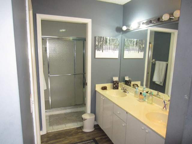 bathroom with an enclosed shower, hardwood / wood-style floors, and dual bowl vanity