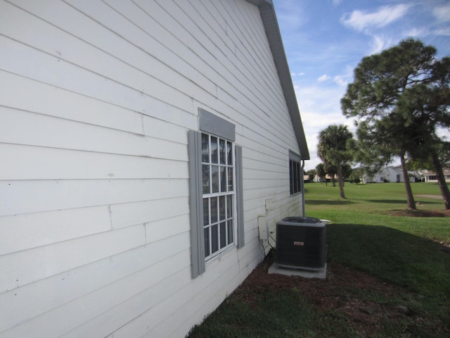 view of property exterior with a lawn and central air condition unit