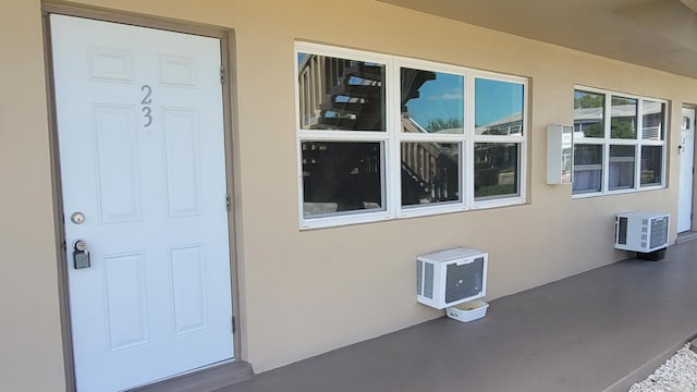 view of exterior entry with a wall unit AC