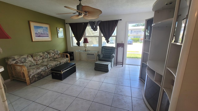 living room featuring tile floors, ceiling fan, and a textured ceiling