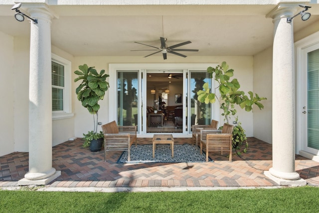 view of exterior entry with ceiling fan and a patio area