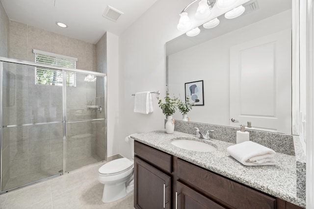 bathroom featuring tile patterned floors, toilet, an enclosed shower, and vanity