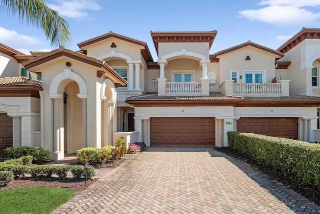 mediterranean / spanish-style home with a garage and a balcony