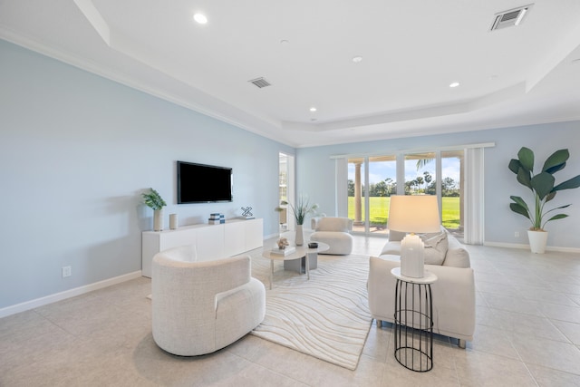 living room with ornamental molding, light tile patterned floors, and a tray ceiling