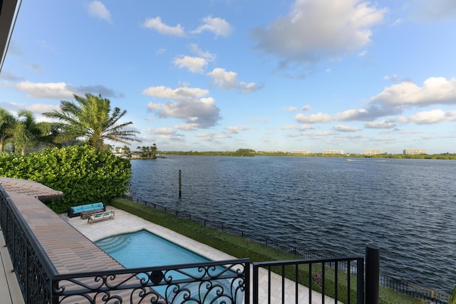 view of swimming pool with a patio area and a water view