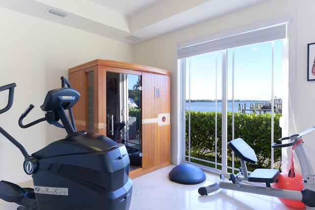 exercise room featuring a water view