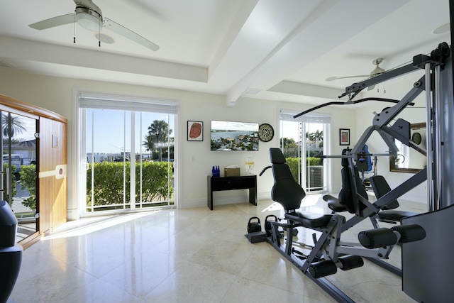 workout area with ceiling fan and a raised ceiling