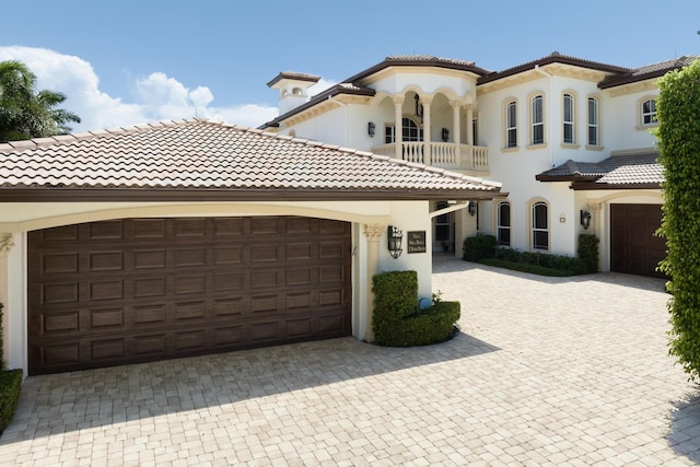 mediterranean / spanish-style home featuring a balcony and a garage