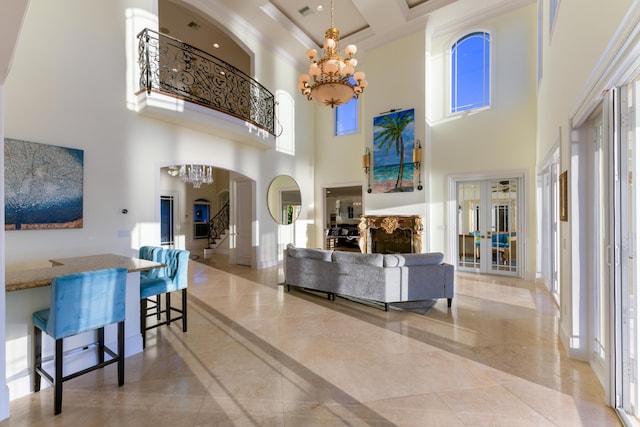 living room with a towering ceiling, a notable chandelier, french doors, and plenty of natural light