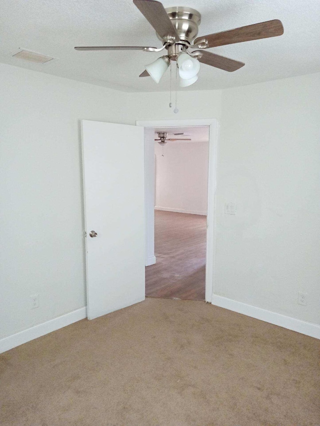 unfurnished room featuring light carpet and ceiling fan